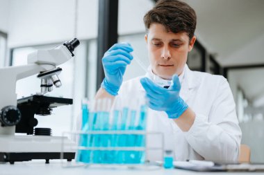 Modern tıbbi araştırma laboratuvarı. Bilimadamı mikro pipetlerle çalışıyor, biyokimyasal örnekleri analiz ediyor, tıp için ileri bilim kimya laboratuvarında çalışıyor..