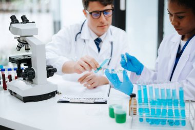 Yetişkin erkek doktor ve Afrikalı kadın hemşire birlikte anesteziyi tartıştılar. Hastanedeki çeşitli tıp uzmanları...