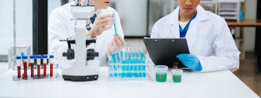 Kimya laboratuvarında kimya sıvılarını karıştıran bilim adamları. Kimya laboratuvarında çalışan bir araştırmacı.