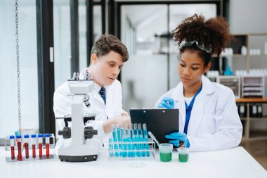 Yetişkin erkek doktor ve Afrikalı kadın hemşire birlikte anesteziyi tartıştılar. Hastanedeki çeşitli tıp uzmanları...