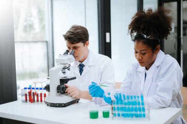 Yetişkin erkek doktor ve Afrikalı kadın hemşire birlikte anesteziyi tartıştılar. Hastanedeki çeşitli tıp uzmanları...