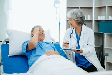 Doktor, Hasta Dinlenmesi 'ni Yatakta Kontrol Ediyor. Hastanede başarılı bir ameliyattan sonra iyileşen adamı kontrol ediyor.