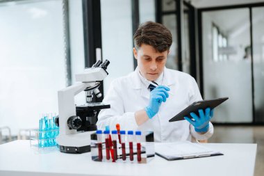 Modern tıbbi araştırma laboratuvarı. Bilimadamı mikro pipetlerle çalışıyor, biyokimyasal örnekleri analiz ediyor, tıp için ileri bilim kimya laboratuvarında çalışıyor..