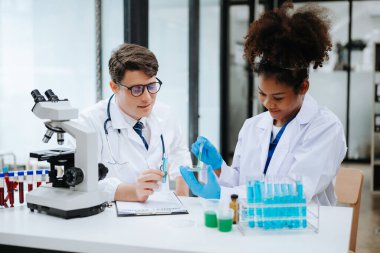 Yetişkin erkek doktor ve Afrikalı kadın hemşire birlikte anesteziyi tartıştılar. Hastanedeki çeşitli tıp uzmanları...