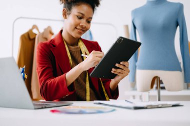 Sakin, kıvırcık esmer, esmer, koyu tenli kadın modern ofiste masa başında çalışıyor.