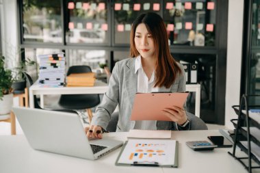 Kadın serbest çalışan dizüstü bilgisayar, muhasebe, analiz, emlak yatırım verileri ve finansal konsept üzerinde çalışıyor. 