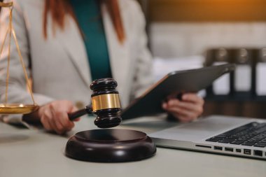 Adalet ve hukuk kavramı. Kadın avukat mahkeme salonunda çalışıyor ve yargılıyor tokmak, dijital tablet bilgisayar üzerinde çalışıyor.
