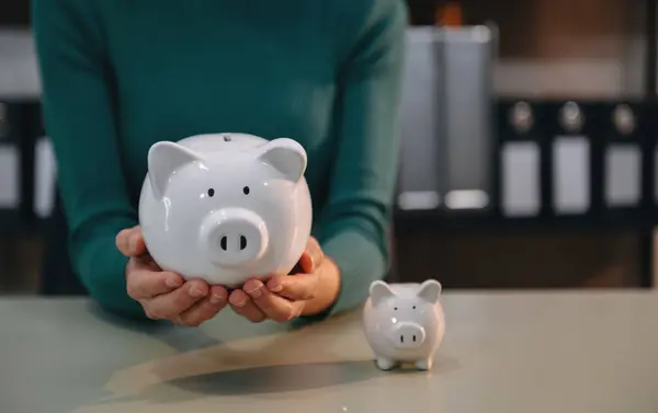 Women are putting coins in a piggy bank for a business that grows for profit and saving money for the future. planning for retirement concep