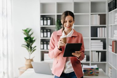 Yaratıcı ofiste dijital tablet üzerinde çalışan kendine güvenen iş uzmanı.