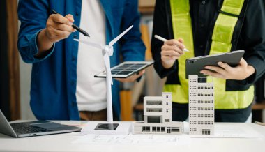 İş adamlarının şirket ofisinde rüzgar enerjisi hakkında görüşleri var. İş ekibi yel değirmeni ve alternatif yeşil enerji hakkında konuşuyor. Modern ofiste yönetici toplantısı.