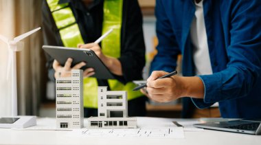 İş adamlarının şirket ofisinde rüzgar enerjisi hakkında görüşleri var. İş ekibi yel değirmeni ve alternatif yeşil enerji hakkında konuşuyor. Modern ofiste yönetici toplantısı.