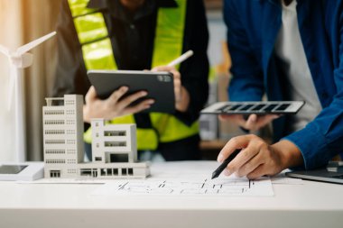 İş adamlarının şirket ofisinde rüzgar enerjisi hakkında görüşleri var. İş ekibi yel değirmeni ve alternatif yeşil enerji hakkında konuşuyor. Modern ofiste yönetici toplantısı.