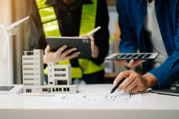 Business people having consultation about wind energy at company office. Business team discussing about windmill and alternative green enery. Executive meeting at modern office