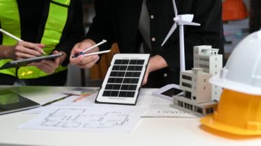 Mühendis ekibi toplanıyor ve ofisteki ekolojik mimari projede birlikte çalışıyor.