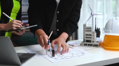 Mühendis ekibi toplanıyor ve ofisteki ekolojik mimari projede birlikte çalışıyor.