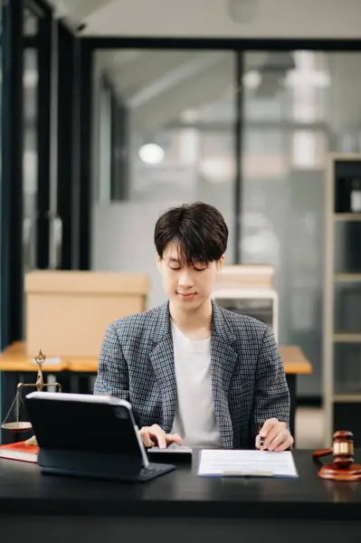 Attractive young lawyer in office Business  working on tablet at desk in modern office. Law, legal services, advice