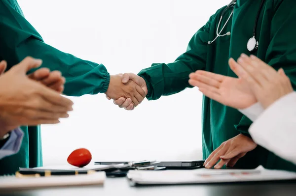 Doctor handshake and partnership in healthcare, medicine or trust for collaboration, unity or support. Team of medical experts shaking hands in teamwork for or success in  hospital