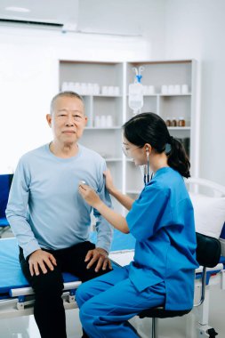  Dost canlısı baş hemşire hasta yatağında dinlenirken onu muayene ediyor.