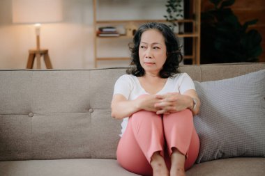 Depresyonda olan bir kadın evdeki koltukta oturur. 