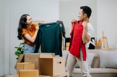 Mutlu Asyalı genç ve çekici çift büyük kutularla yeni bir eve taşınıyor.