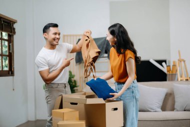 Mutlu Asyalı genç ve çekici çift büyük kutularla yeni bir eve taşınıyor.
