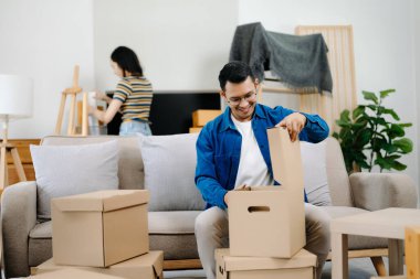 Mutlu Asyalı genç ve çekici çift büyük kutularla yeni bir eve taşınıyor.