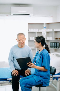  Dost canlısı baş hemşire hasta yatağında dinlenirken onu muayene ediyor.