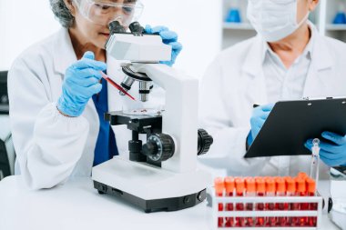 Bilimadamı ekip buluşması ve yazım analizi laboratuvarda küresel ısınma, analitik ve teknoloji için bilimsel örnekler inceler ve analiz eder.