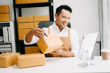 Başlangıçta küçük işletme KOBİ 'si, girişimci sahibi tablet kullanarak paket ürün kutularını hazırlamak için çevrimiçi alışveriş siparişini alır ve kontrol eder 