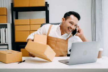 Akıllı telefon kullanarak çalışan Asyalı genç KOBİ 'nin portresi müşteriye online alışveriş siparişi almak ve kontrol etmek, serbest ticaret konsepti