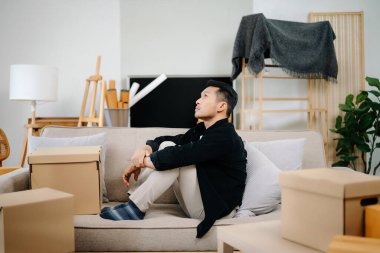 Depresyonda olan bir adam evdeki koltukta oturur. 