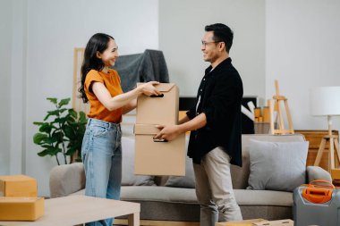 Mutlu Asyalı genç ve çekici çift büyük kutularla yeni bir eve taşınıyor.