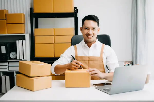 Young man running online store Startup small business SME, receive and checking online purchase shopping order in office