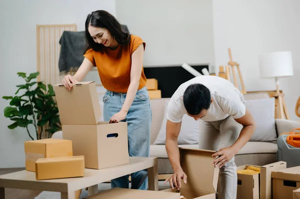 Mutlu Asyalı genç ve çekici çift büyük kutularla yeni bir eve taşınıyor.