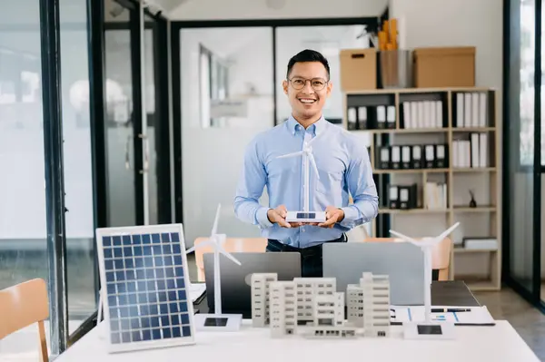 stock image Male alternative energy engineer working with  windmill power sample model in the modern office 