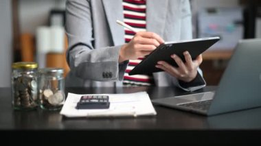 Ofiste dijital tablet üzerinde çalışan iş kadını veya muhasebecinin elleri.