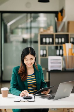 Modern ofiste tablet bilgisayarda çalışan genç ve güzel bir kadın.