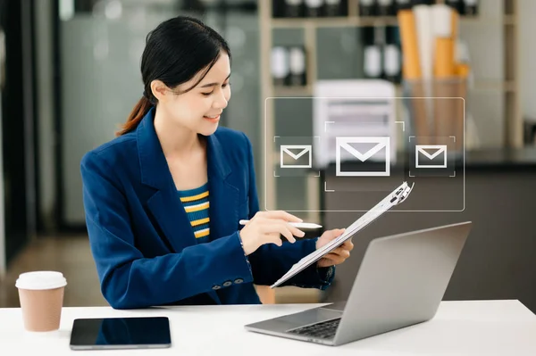 Woman hands using Laptop and surfing the internet with email icon, email marketing concept, send e-mail or newsletter, online working internet network technology. in office