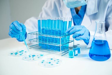 Kimya laboratuvarında kimyasal sıvıları karıştıran bir bilim adamı. Kimya laboratuvarında çalışan araştırmacı ve yeni kimyasal madde.