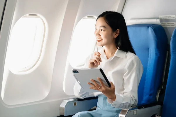 Young Asian executive excels in first class. Travel in style, work with grace in morning