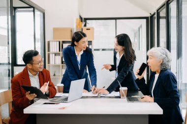 İş ekibi toplantı odasında tartışır. Masada dizüstü bilgisayar, tablet ve akıllı telefonla çalışmak muhasebeci, planlamacı, toplantı, tanıtım konsepti. Ofiste.