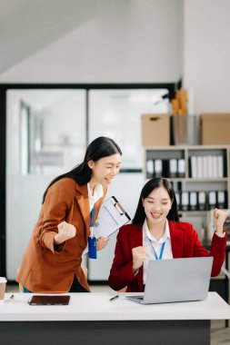 Genç Asyalı iş adamları, modern ofiste yaratıcılığı ve tasarımı kutluyor.  