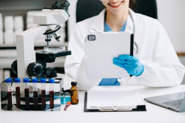 Kadın araştırmacı kimya laboratuvarında bir deney yürütüyor.