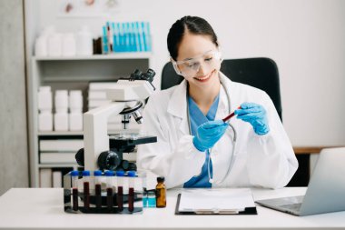 Kadın araştırmacı kimya laboratuvarında bir deney yürütüyor.