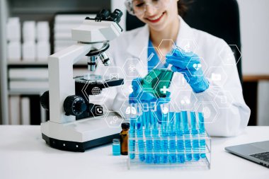 Doktor laboratuarda mikroskop kullanıyor ve sanal simge ile çalışıyor