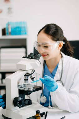 Modern tıbbi araştırma laboratuvarı. Kadın bilim adamı mikro pipetlerle çalışıyor biyokimyasal örnekleri analiz ediyor, tıp için ileri bilim kimya laboratuvarı.