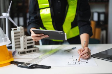 Yaratıcı mimarın orta bölümü modern ofiste mimari projeler üzerinde çalışıyor.