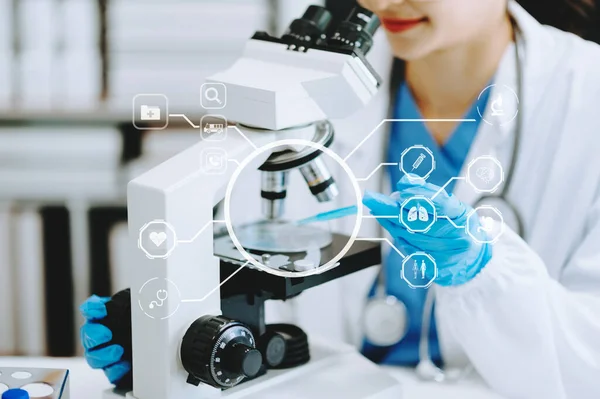 Doctor using microscope in laboratory and  study with virtual icon