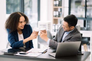 İş adamları, modern ofisteki yeni başlatılan konferans odasında başarıyı kutlamak için çok çalışıyorlar.