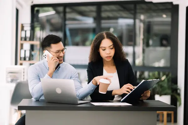 Stock image Two Asian business people discuss investment project working and planning strategy in  office